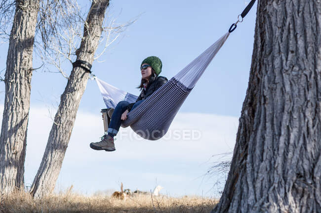 Woman sitting in hammock drinking coffee, Wyoming, America, USA — Stock Photo