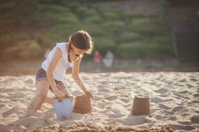 Девушка на пляже строит песчаный замок, Болгария — стоковое фото