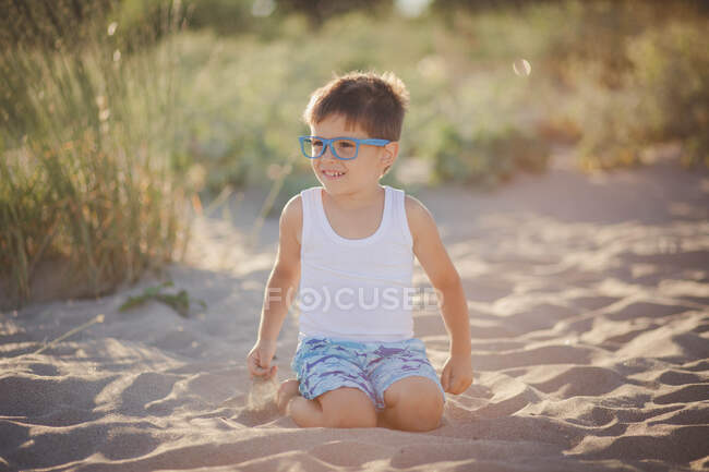Portrait of a smiling boy sitting on beach, Bulgaria — Stock Photo