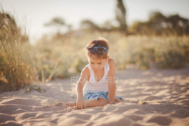 Retrato de um menino sentado na praia brincando com areia, Bulgária — Fotografia de Stock