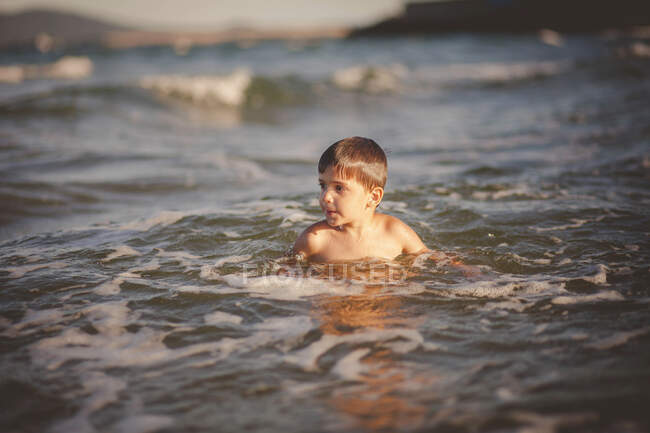 Niño sonriente nadando en el mar, Bulgaria - foto de stock