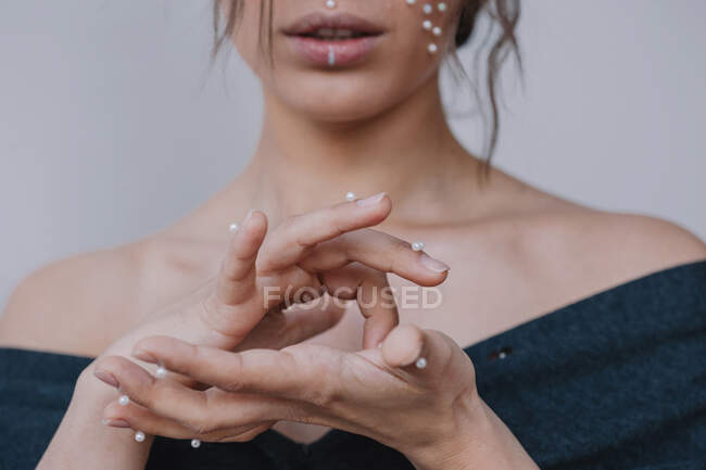 Retrato de una mujer con perlas en los dedos - foto de stock