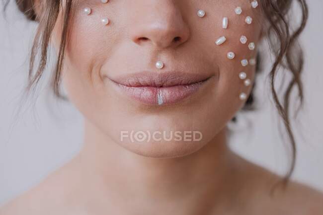 Retrato de uma mulher com pérolas no rosto sorrindo — Fotografia de Stock