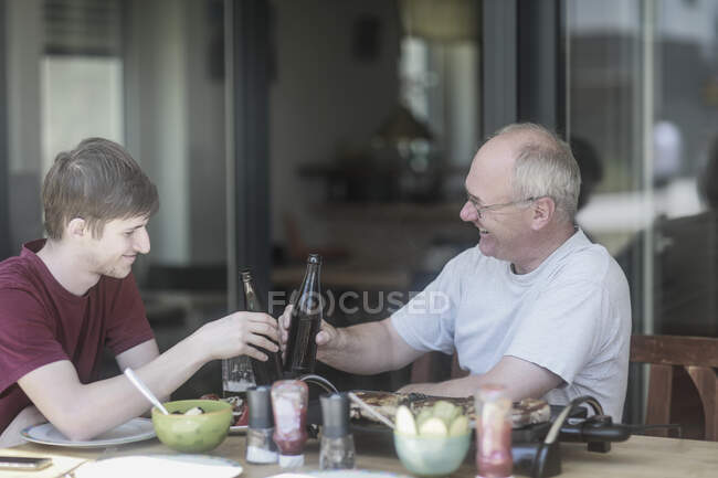 Pai e filho fazendo um brinde comemorativo — Fotografia de Stock