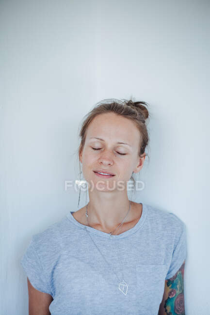 Retrato de una mujer sonriente con los ojos cerrados - foto de stock