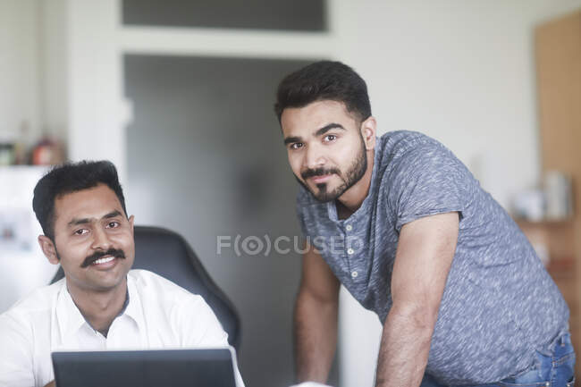 Dos hombres trabajando juntos en casa - foto de stock