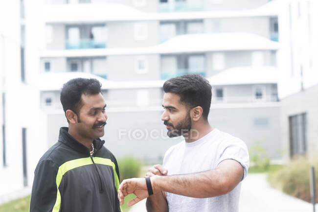 Two joggers looking at a smart watch — Stock Photo