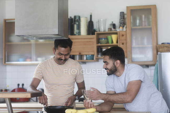 Dos hombres preparando la cena juntos - foto de stock
