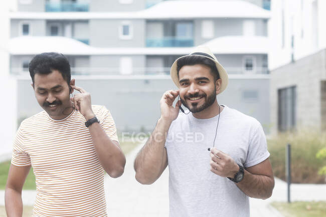 Двое мужчин слушают музыку на мобильном телефоне — стоковое фото