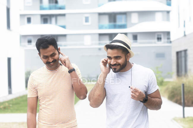 Двое мужчин слушают музыку на мобильном телефоне — стоковое фото