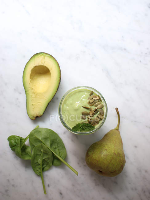 Avocado, spinach and pear smoothie with mint and pumpkin seeds — Stock Photo