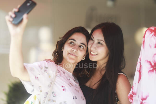 Deux femmes debout dans un magasin prenant un selfie — Photo de stock