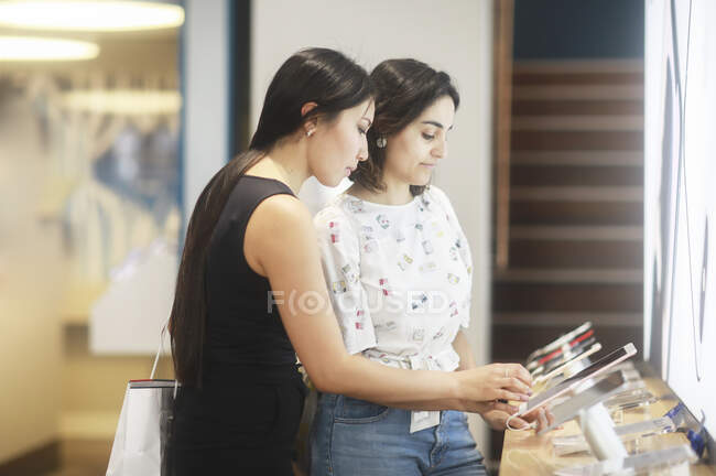 Two women shopping for mobile phones — Stock Photo
