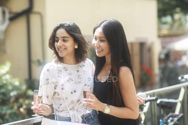 Дві жінки насолоджуються випивкою після покупки — стокове фото