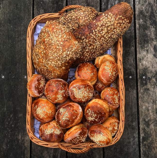 Rouleaux de pain frais et pains dans un panier — Photo de stock