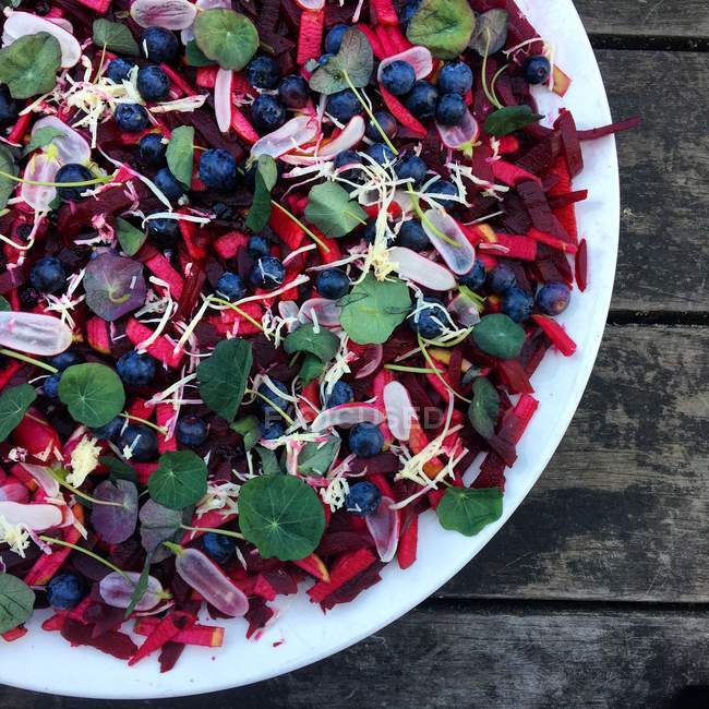 Beetroot, blueberry and horseradish salad over wooden table — Stock Photo