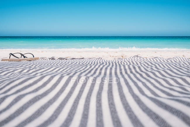 Vista panorámica de chanclas en una toalla de playa, Australia - foto de stock
