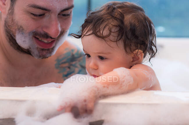 Man bathing with baby in a bathtub — Stock Photo