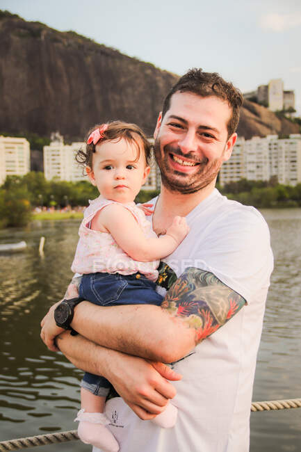 Retrato de un hombre sosteniendo a su hija, Rodrigo de Freitas Lagoon, Rio de Janeiro, Brasil - foto de stock