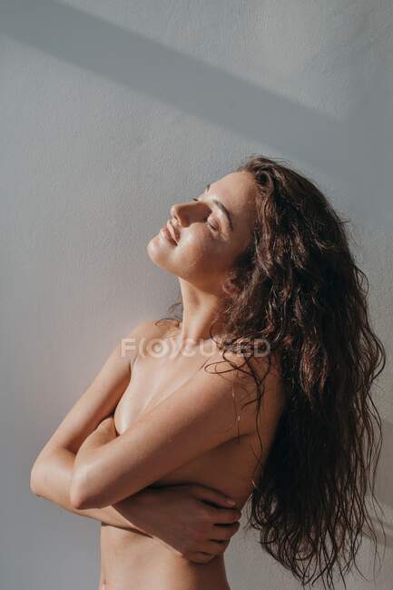 Retrato de una hermosa mujer cubriéndose los pechos - foto de stock