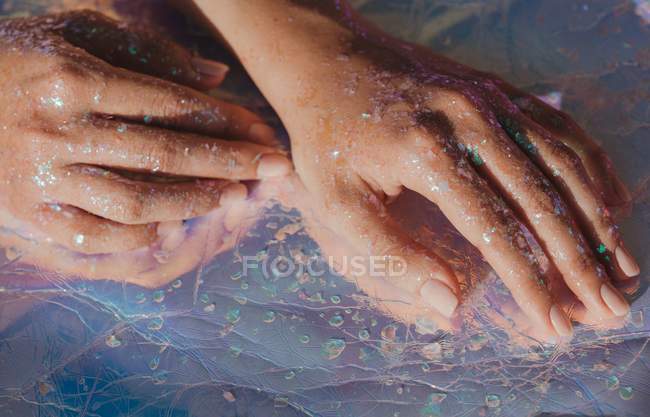 Nahaufnahme weiblicher Hände, die mit Glitzer bedeckt sind — Stockfoto