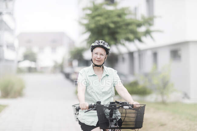 Mulher pedalando em uma e-bike — Fotografia de Stock