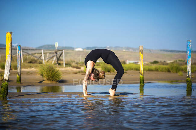 Frau am Strand von Los Lances beim Rad-Yoga, Tarifa, Cadiz, Andalusien, Spanien — Stockfoto