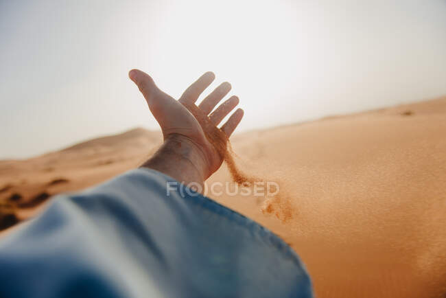 Sand läuft durch die Hand eines Mannes in der Wüste, Marokko — Stockfoto