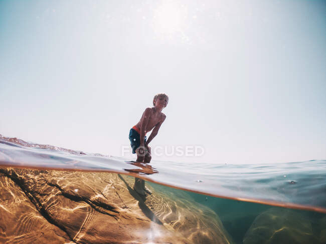 Boy standing on a rock in lake Superior, Stati Uniti — Foto stock