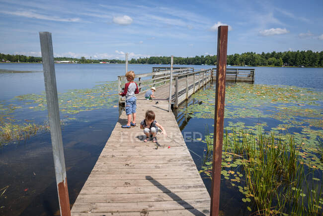 Drei Kinder angeln im Sommer auf einem Steg, Vereinigte Staaten — Stockfoto