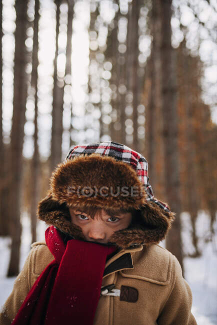 Портрет мальчика в лесу в зимней шляпе и теплом пальто — стоковое фото