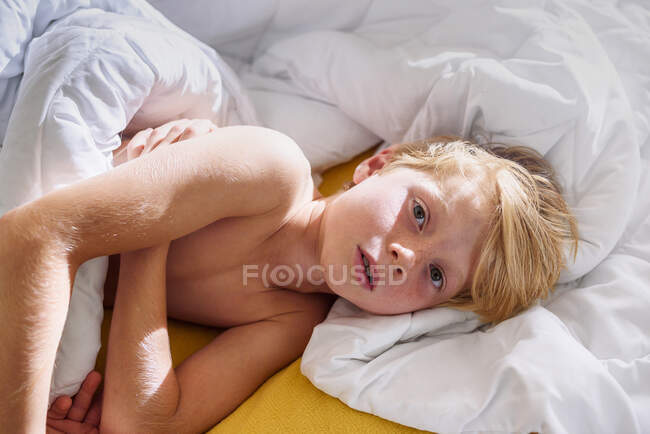Vista aérea de un niño acostado en la cama - foto de stock