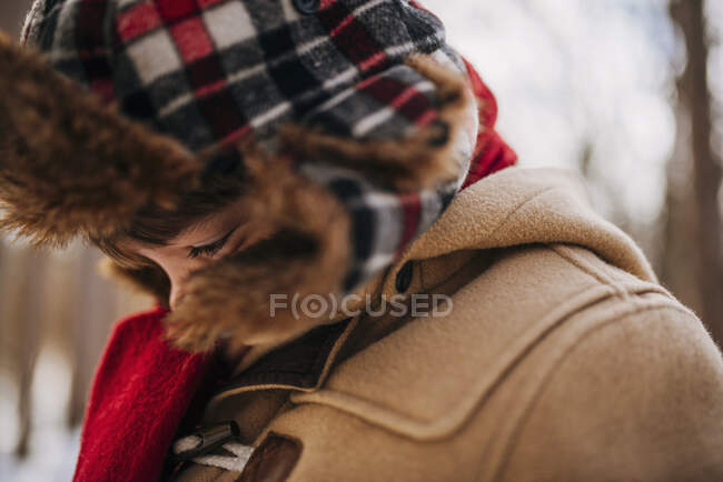 Portrait d'un garçon dans les bois portant un chapeau d'hiver et un manteau chaud — Photo de stock