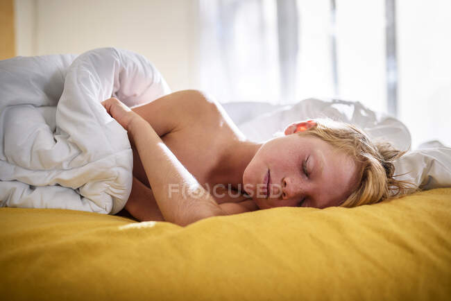 Niño durmiendo en la cama - foto de stock