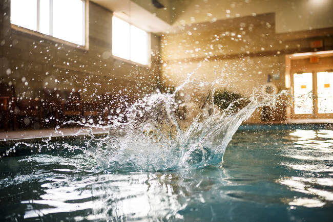 Wasser plätschert in einem Swimmingpool, nachdem eine Person hineinspringt — Stockfoto