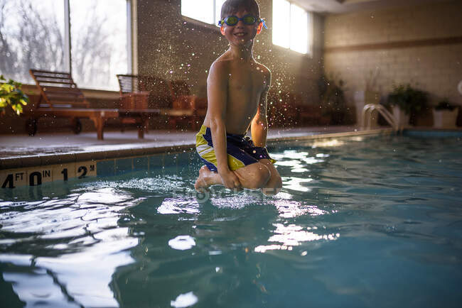 Garçon sautant dans une piscine — Photo de stock
