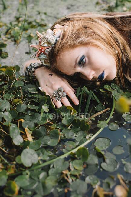 Retrato de una mujer boho acostada en el lago, Rusia - foto de stock
