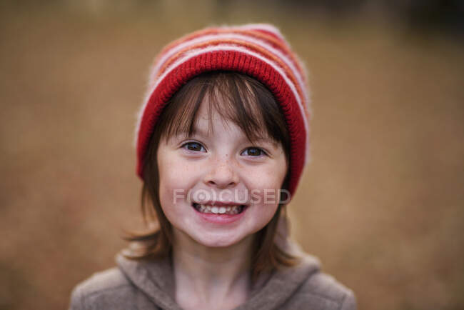 Portrait d'une fille souriante portant un chapeau laineux — Photo de stock