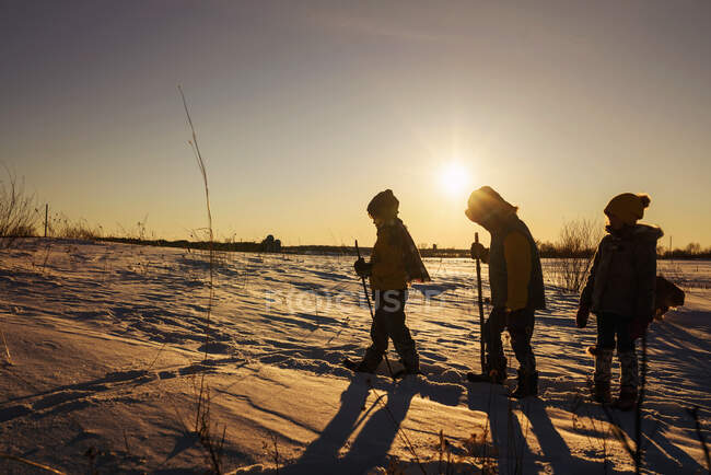 Silhouette of three children hiking through the snow, United States — Stock Photo