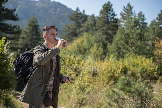 Caminhante em pé na água potável da floresta, Bósnia e Herzegovina — Fotografia de Stock