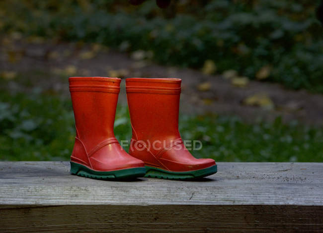 Vista da vicino di stivali Red wellington su una panchina di legno — Foto stock
