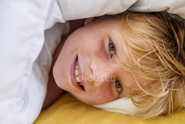 Портрет усміхненого хлопчика, що лежить у ліжку — стокове фото