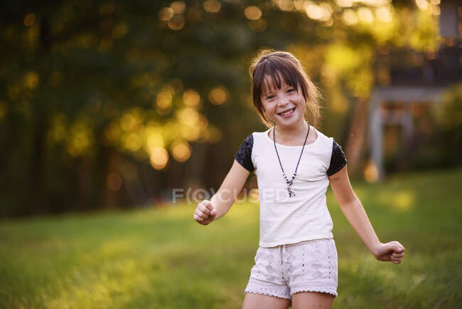 Retrato de uma menina sorridente dançando no parque — Fotografia de Stock