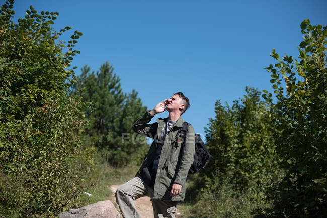 Hiker standing on a footpath talking on his mobile phone, Bosnia and Herzegovina — Stock Photo