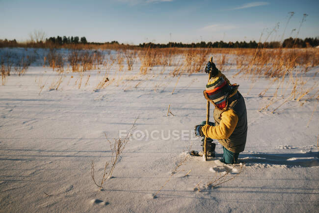 Chico caminando en nieve profunda, Estados Unidos - foto de stock