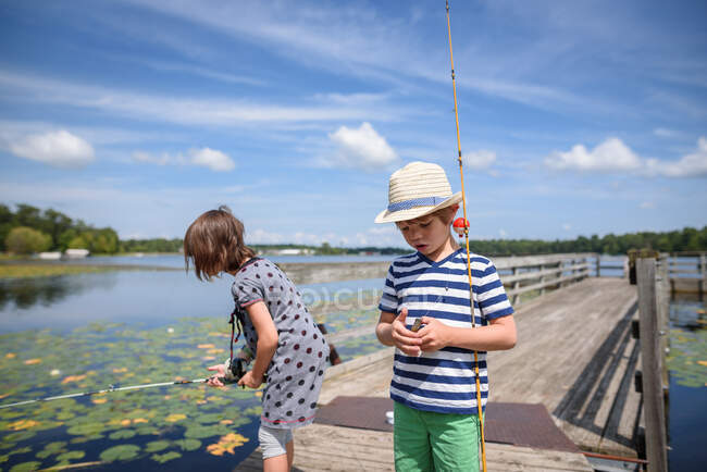 Two children fishing on a dock in the summer, United States — Stock Photo