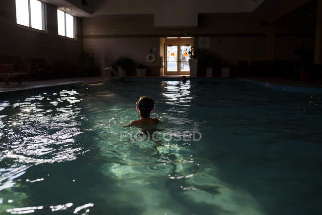 Boy wearing swimming goggles in a swimming pool — Stock Photo
