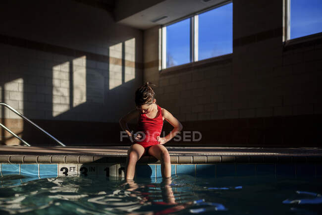 Ragazza seduta sul bordo di una piscina — Foto stock