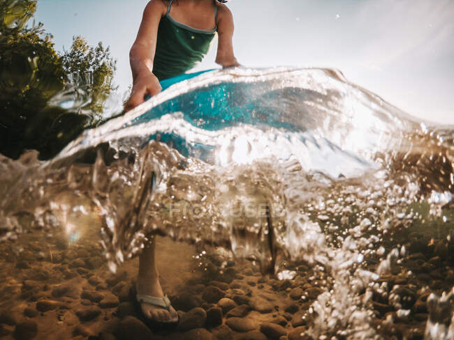 Girl standing in a lake emptying a bucket of water, Lake Superior, Estados Unidos — Fotografia de Stock