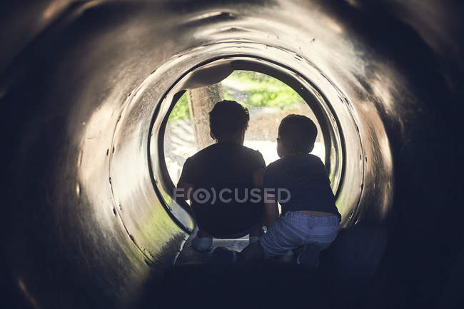 Силуэт двух мальчиков, играющих в туннеле — стоковое фото